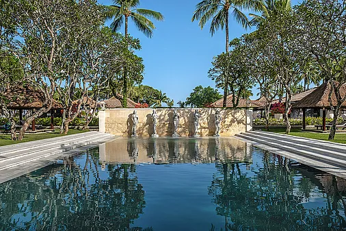 Balinesische Statuen schmücken den Pool im Hotel auf Bali